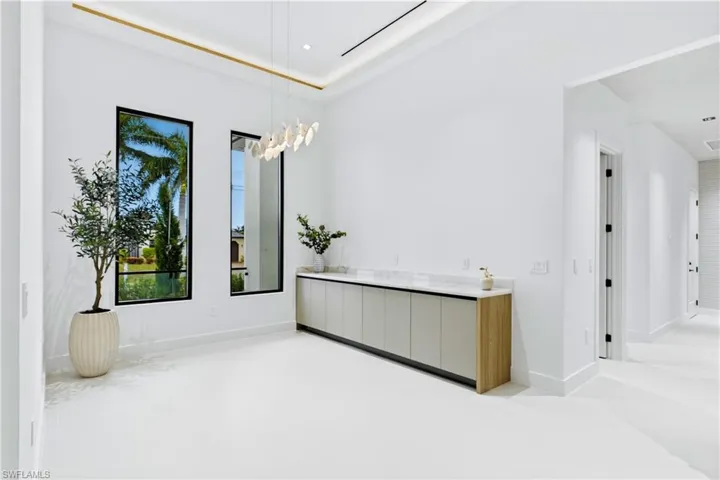 Sophisticated formal dining w/ tray ceiling wood accents, statement lighting, 2 oversized 8-ft picture windows & built-in buffet w/ extra cabinetry & serving space