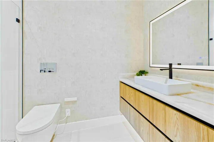 Bright en-suite bath with a floating-style vanity, vessel sink, and sleek modern finishes that keep the space clean and refined