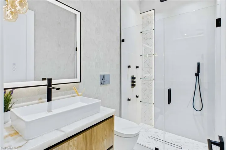 Stylish en-suite bath with a modern vanity, vessel sink, and clean contemporary finishes