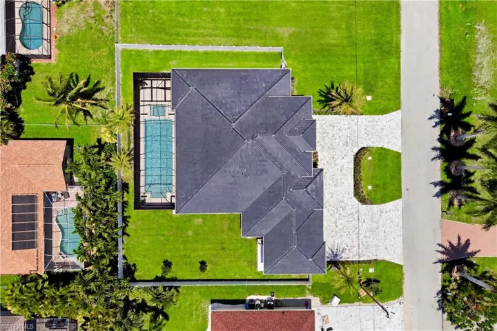 RARE TRIPLE-LOT MODERN ESTATE in the HEART of SW Cape Coral w/ 4,861 total sq ft, HIGH-END FINISHES, 45-ft RESORT POOL & OVERSIZED SPA, GRAND CIRCULAR DRIVEWAY & EXPANSIVE YARD w/ room for toys, watercraft or extra outdoor living!