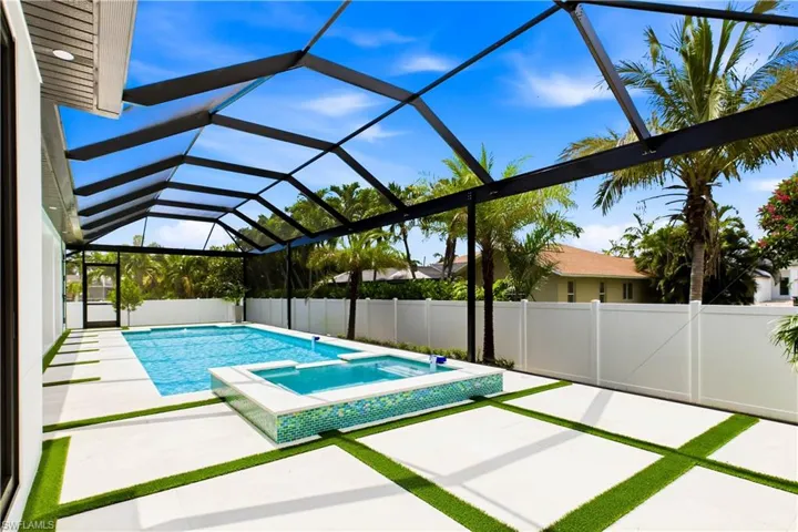 Oversized heated saltwater pool & spa & marble pavers w/ artificial turf inlays