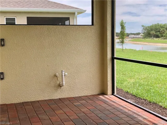 Exterior view of stucco siding, nearby water, and a downspout