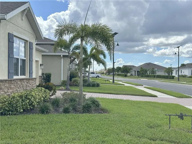 View of green lawn with a residential view