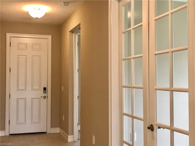 Hall featuring baseboards and french doors