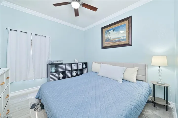 Bedroom with ornamental molding and a ceiling fan