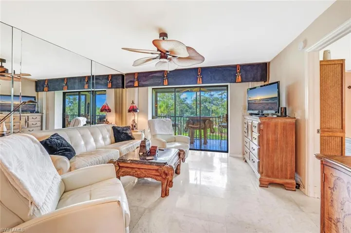 Tiled living room with plenty of natural light and ceiling fan