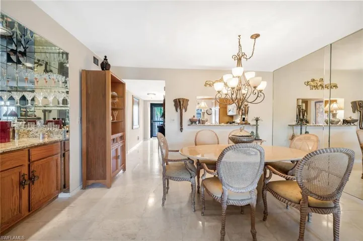Dining room with light tile patterned flooring and a chandelier