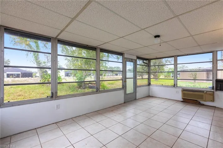 Unfurnished sunroom with plenty of natural light and cooling unit