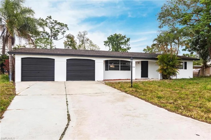 Single story home featuring stucco siding, concrete driveway, a front lawn, and an attached garage