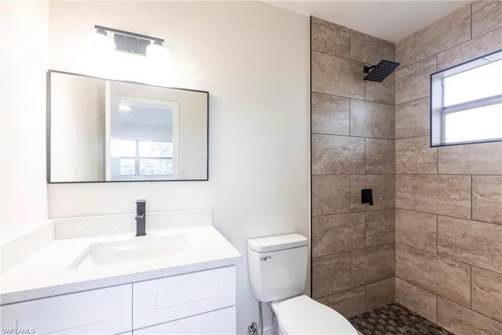 Bathroom with vanity and tiled shower