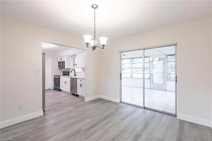 Unfurnished dining area featuring light wood-style flooring and a chandelier