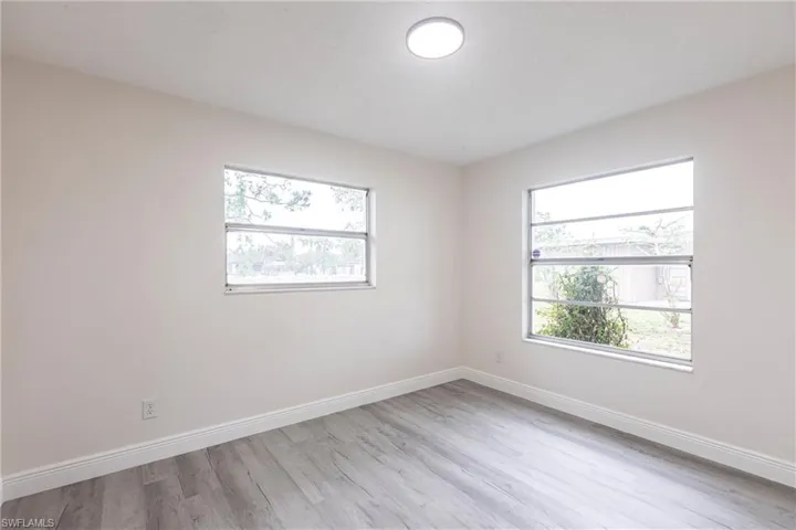 Unfurnished room with wood finished floors and healthy amount of natural light