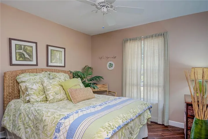 Bedroom featuring dark wood-style floors, ceiling fan, and baseboards