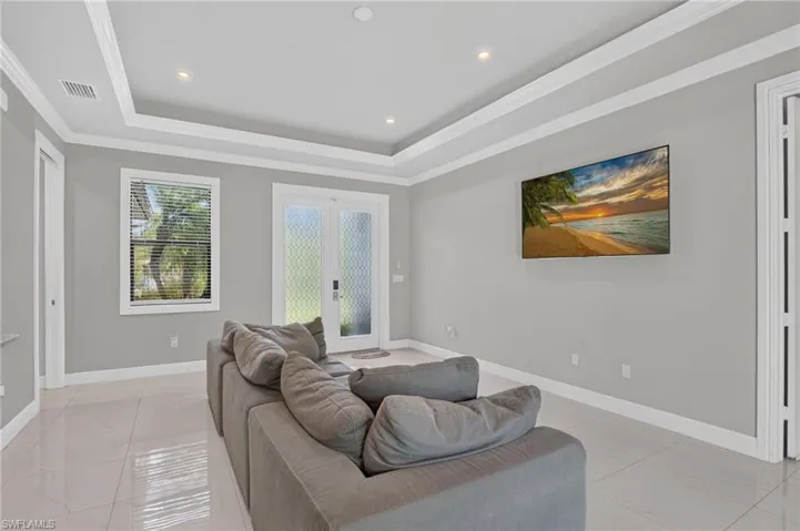 Recessed lighting, tray ceiling, tile flooring, and frosted glass double doors