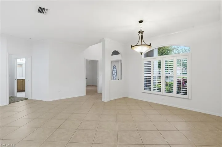 Living room with ornamental molding and light tile patterned floors