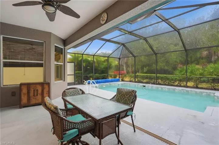 Outdoor pool with a lanai, patio area, and outdoor dining space