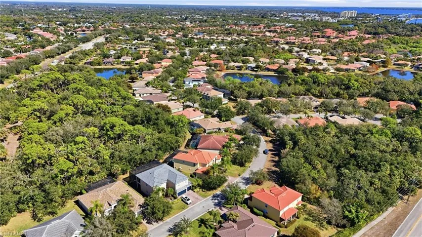 Aerial view of property and surrounding area with nearby suburban area and a large body of water