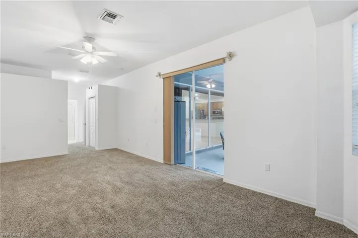 Unfurnished room with a ceiling fan and carpet flooring