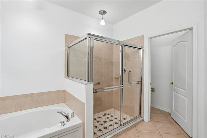 Bathroom with a garden tub, a stall shower, and light tile patterned floors