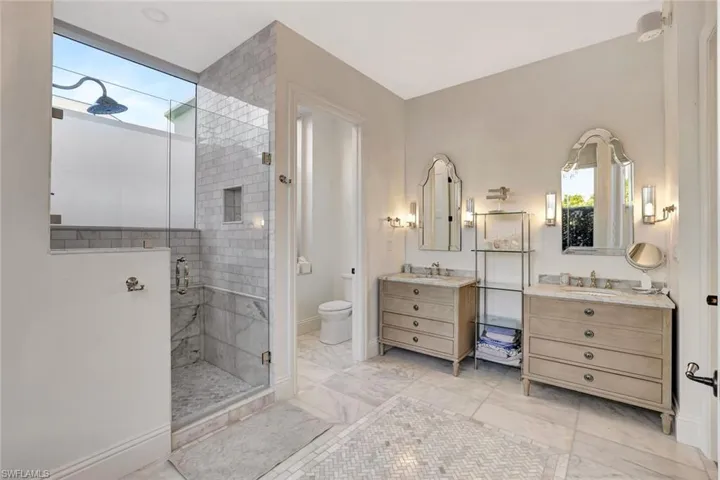 Master bath with a stall shower and two vanities