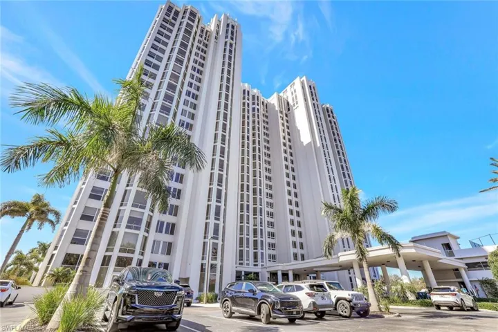 View of apartment building / complex featuring uncovered parking