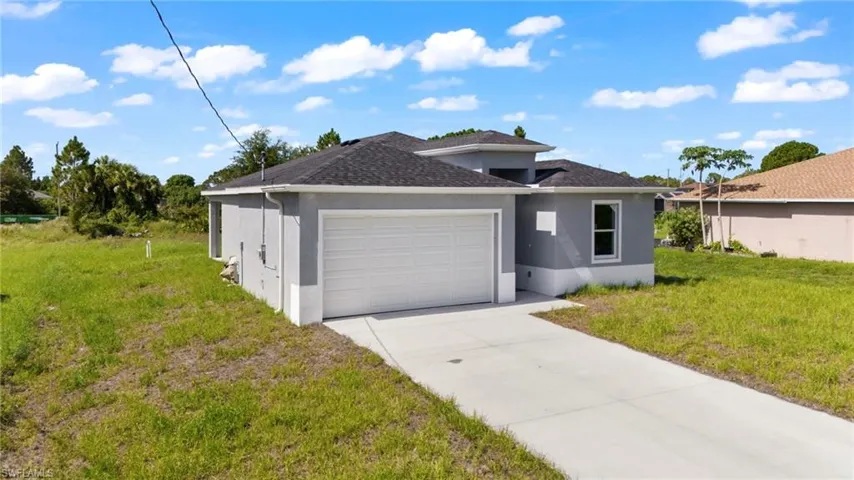 View of front of house with a garage and a front lawn