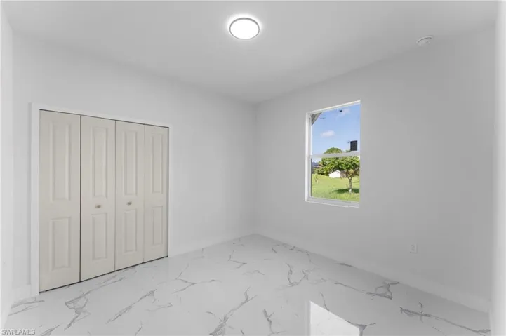 Unfurnished bedroom featuring light tile patterned flooring and a closet