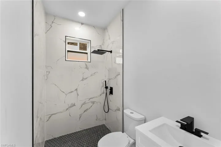 Bathroom with vanity, toilet, and a tile shower
