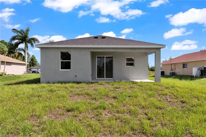 Rear view of property with a lawn