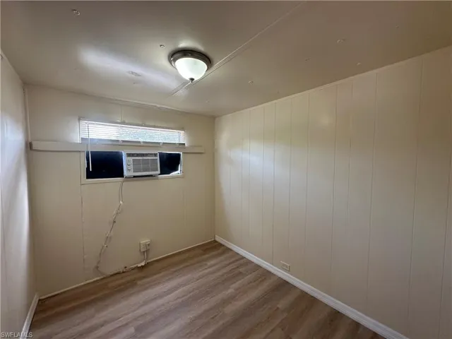 Unfurnished room featuring wood finished floors and wooden walls