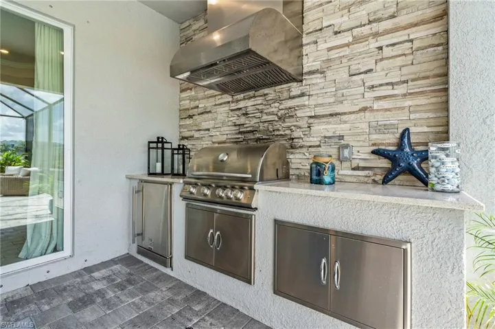 Kitchen featuring wall chimney range hood and light countertops