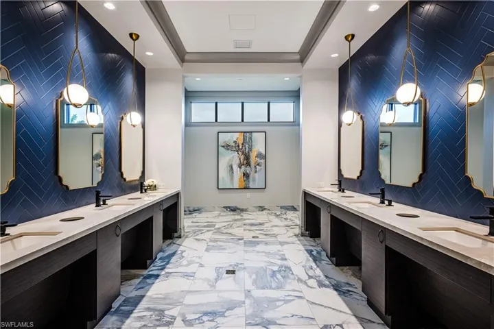 Full bathroom featuring double vanity, a sink, and tile walls