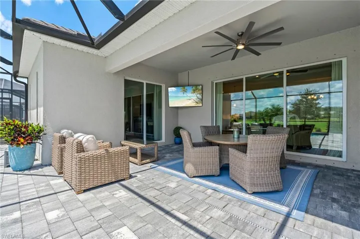 View of patio / terrace featuring a ceiling fan, outdoor dining area, and a lanai