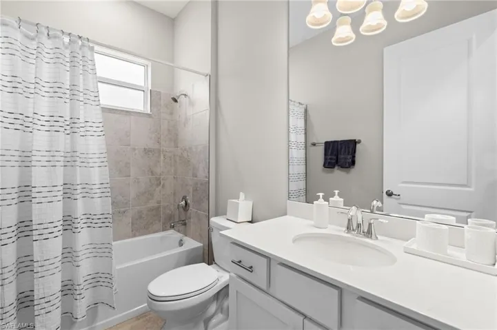 Full bath featuring shower / bath combo with shower curtain, vanity, and toilet