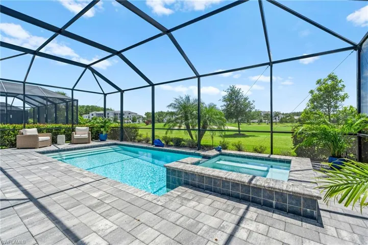 View of pool featuring a lanai, a patio, and a pool with connected hot tub