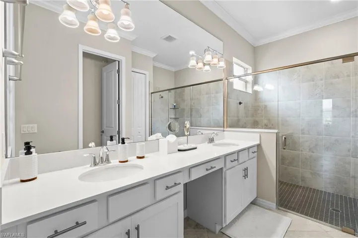 Full bath featuring a sink, a chandelier, and a stall shower