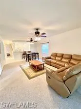 Living area featuring a ceiling fan and carpet floors
