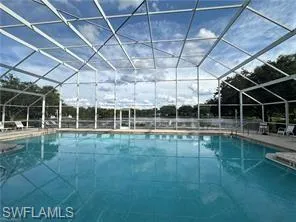 Outdoor pool featuring fully screened enclosure, sunroom with sundeck, and a patio and clubhouse