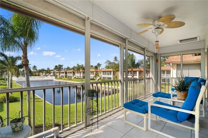 Sunroom / solarium with a water view and tile patterned flooring
