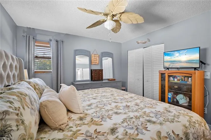 Bedroom featuring a textured ceiling, a closet, and a ceiling fan