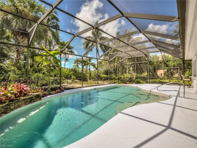 View of swimming pool featuring a patio and glass enclosure