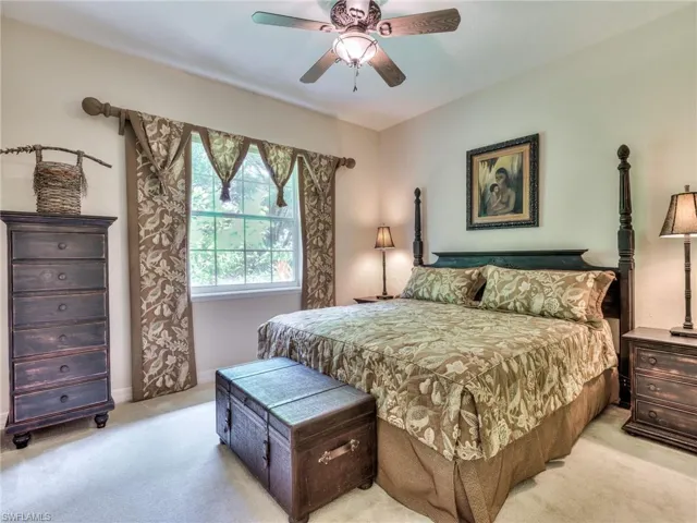 Carpeted bedroom featuring ceiling fan