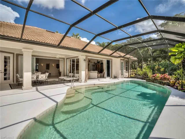 View of swimming pool with a patio, glass enclosure, and ceiling fan