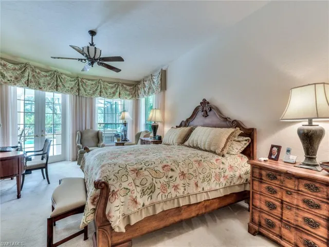 Carpeted bedroom with ceiling fan and access to exterior