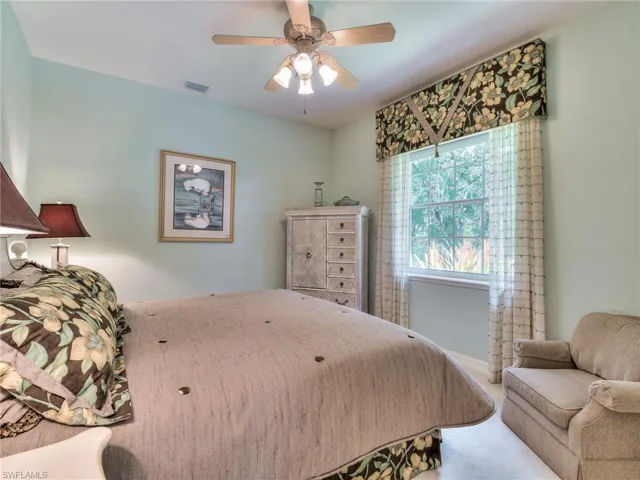 Bedroom with ceiling fan and light carpet