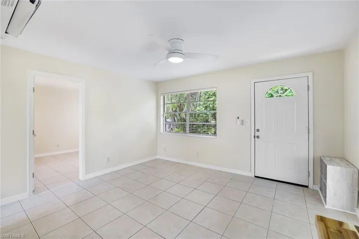 Foyer entrance with light tile patterned floors and a ceiling fan