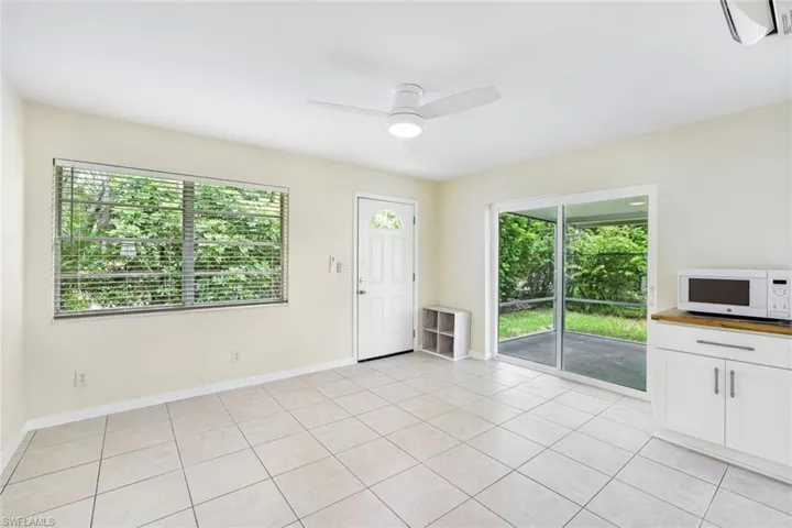 Unfurnished living room featuring plenty of natural light, a ceiling fan, and light tile patterned floors