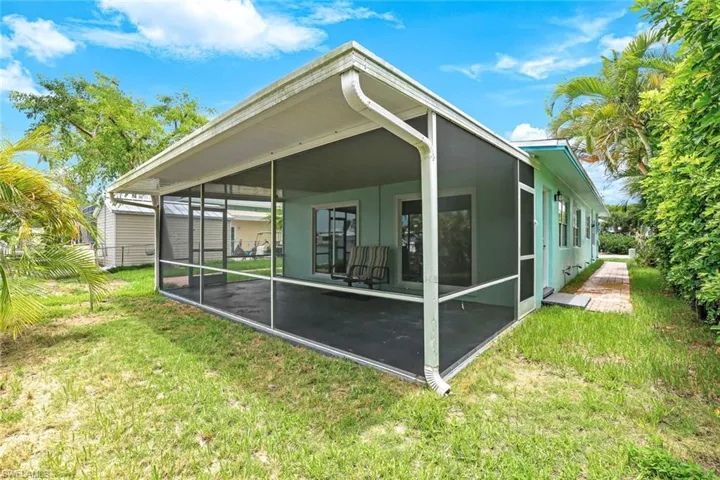 Back of property featuring a sunroom and a yard