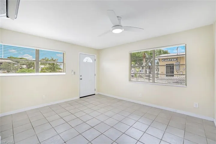 Foyer with healthy amount of natural light, ceiling fan, and light tile patterned flooring