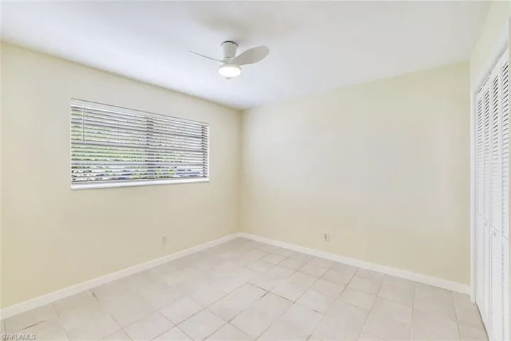 Unfurnished bedroom featuring ceiling fan, a closet, and light tile patterned flooring